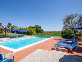 Poolbereich mit Liegen und Sonnenschirmen