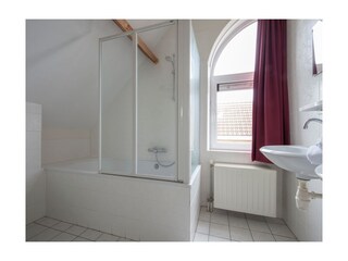 Das helle Badezimmer mit Badewanne und Dusche
