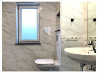 Das Tageslichtbad bietet Fenster, eine Echtglasdusche