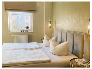 Das Schlafzimmer hat ein Raffrollo mit Verdunkelung.