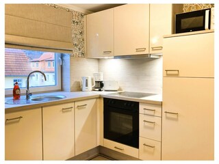 Die Küchenzeile mit Geschirrspüler, Backofen usw.