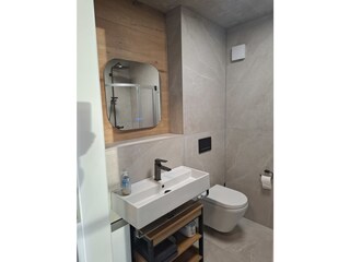 modernes Bad mit WC, Dusche, Fön und Waschtrockner