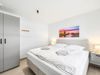Schlafzimmer mit Doppelbett und TV