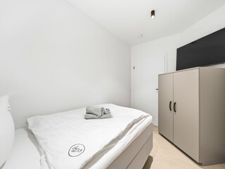 2. Schlafzimmer mit Einzelbett und Kommode