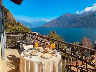 Privater Balkon mit Markise und einem romantischen Panorama auf den See und die Alpen