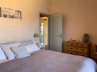 Schlafzimmer mit Doppelbett und herrlichem See- und Bergblick sowie Zugang zum Balkon