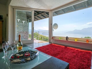 Großzügiger, lichtdurchfluteter Wohn-/ Essbereich mit Panoramafenster, Ledersofas, Kamin, Esstisc...