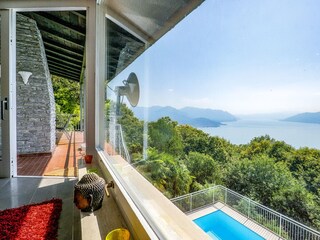 Großzügiger, lichtdurchfluteter Wohn-/ Essbereich mit Panoramafenster, Ledersofas, Kamin, Esstisc...