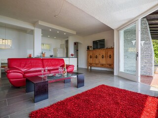 Großzügiger, lichtdurchfluteter Wohn-/ Essbereich mit Panoramafenster, Ledersofas, Kamin, Esstisc...