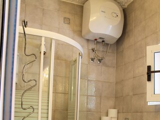 Freundliches Bad mit Waschmaschine, Dusche und Fenster