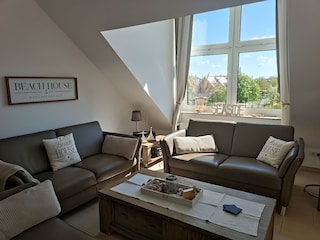 Drei Ledersofas und riesige Fenstergauben im Wohnzimmer