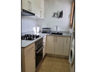 Küche mit Waschmaschine, Geschirrspüler und Backofen