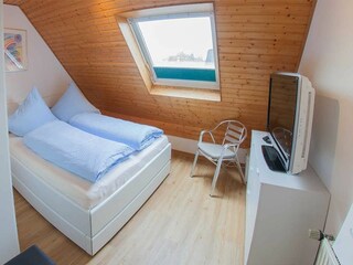 Schlafraum 1 mit Doppelbett und zusätzlichem TV