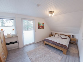 Schlafzimmer eins mit Doppelbett und Ausgang zum Balkon