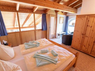 Schlafempore mit Doppelbett - Sitzecke rechts