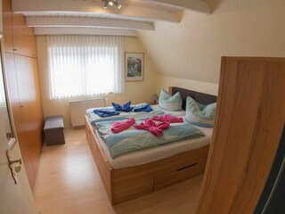 Schlafzimmer mit Doppelbett und Kleiderschrank