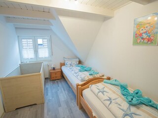 Schlafraum 3 mit zwei Einzelbetten und Kinderholzbett