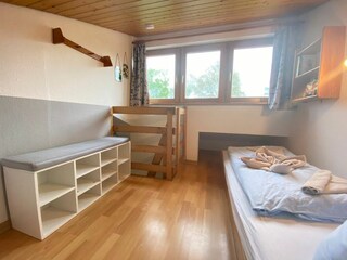 Emporen-Schlafbereich mit den beiden Einzelbetten - steile Leiter führt nach oben