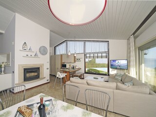 Wohnzimmer mit Esstisch und Seeblick