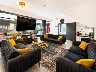 Wohnbereich mit Lounge für viele Leute und 86 Zoll TV