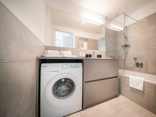 Badezimmer mit Badewanne und integrierter Dusche