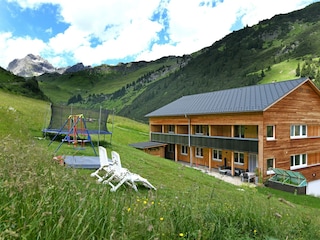 Haus mit Spielplatz und Grillplatz im Hintergrund