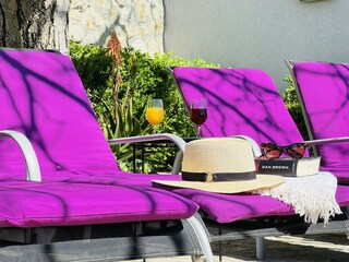 Terrasse am Pool mit Sonnenliegen und Meerblick