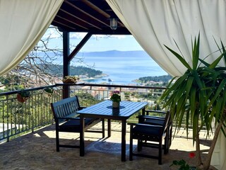 Überdachte Terrasse  mit Esstisch und Meerblick