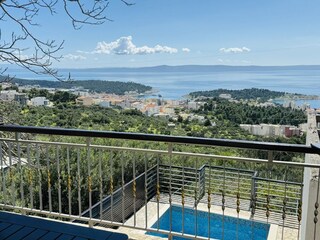 Terrasse am Pool mit Sonnenliegen und Meerblick