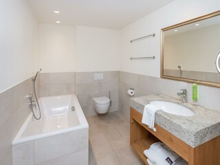 Badezimmer mit Badewanne und Dusche