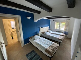 Schlafzimmer mit Doppelbett und zusätzlichem Bett