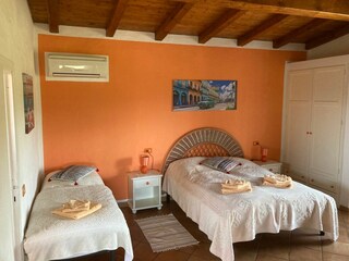 Schlafzimmer mit Doppelbett und zusätzlichem Bett