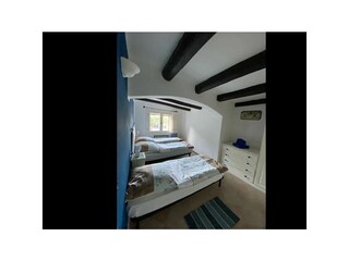 Schlafzimmer mit Doppelbett und zusätzlichem Einzelbett