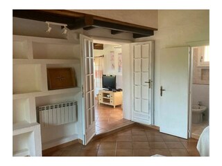 Schlafzimmer mit Blick ins Wohnzimmer sowie Badezimmer