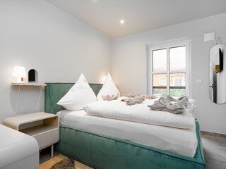 zweites Schlafzimmer mit Boxspringbett und TV