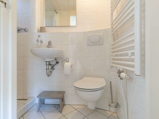 Badezimmer mit Dusche, Waschbecken und Toilette