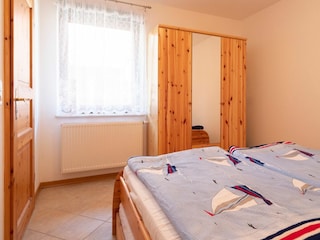 Schlafzimmer mit Doppelbett und Kleiderschrank