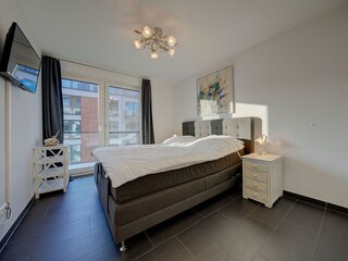 1. Schlafzimmer mit Doppelboxspringbett und TV