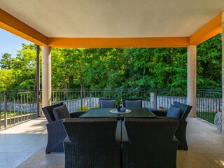 Covered outdoor dining terrace with green views