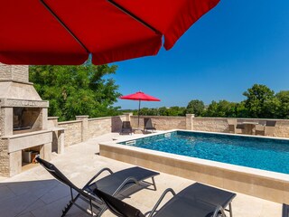 Pool terrace with sun loungers, parasols & barbecue