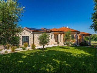 Landscaped garden, stone façade and olive trees