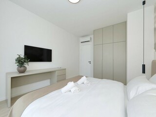 Schlafzimmer mit TV und Kleiderschrank in Villa D3