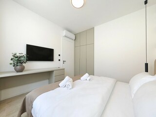 Schlafzimmer mit TV und Kleiderschrank in Villa