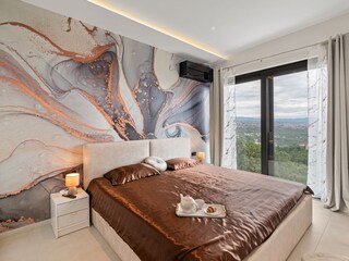 Doppelzimmer der Villa mit Balkontüren und Ausblick