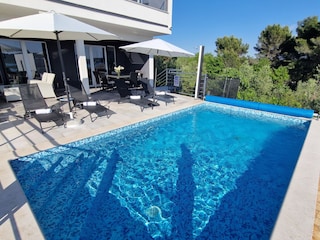 Privater Pool und Sonnenliegen neben der Villa