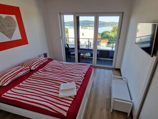 Bequemes Schlafzimmer mit TV und Balkon in Villa