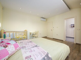 Schlafzimmer mit Doppelbett und Babybett in Villa