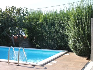 Poolterrasse der Villa Val mit mediterranem Grün