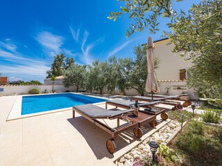 Sun loungers and parasols next to private pool