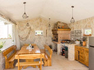Outdoor kitchen with grill and dining table